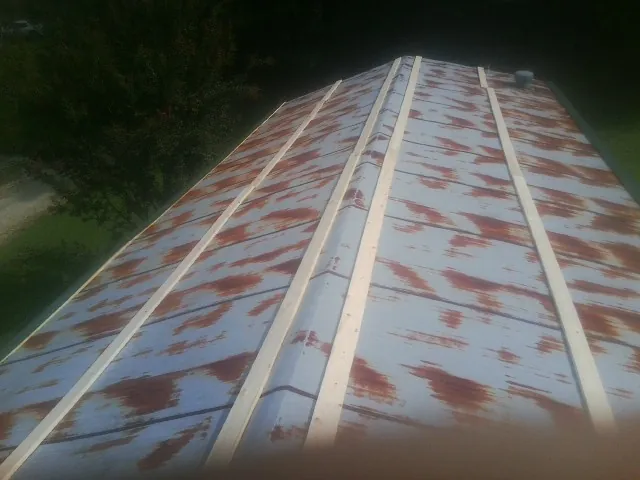 Rusted metal roof panels with new wood purlins before replacement — Storm Damage Roof Repair in Twin City by Roofing Brothers