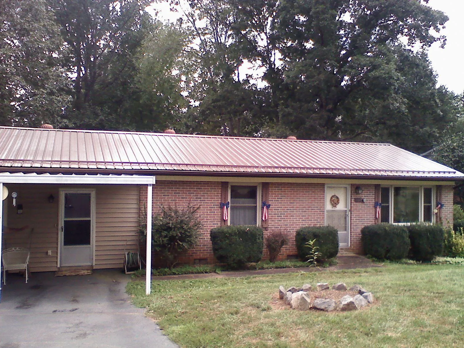 Bronze metal roof and carport on a brick ranch home — Roof Repair work by our crew in Twin City